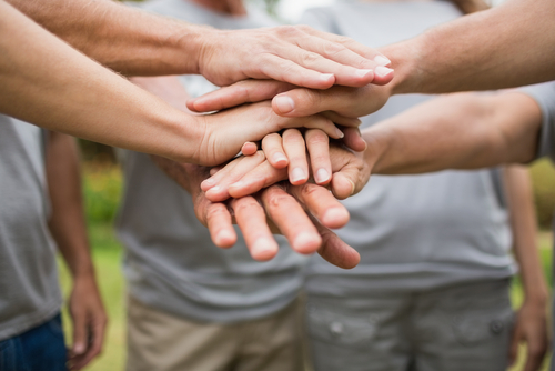 People all putting hands in middle