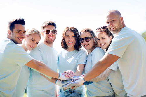 Group of volunteers putting hands together