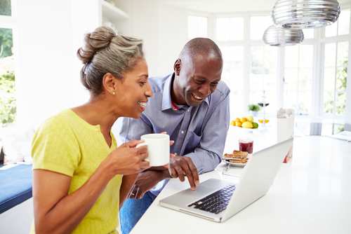 Couple looking at computer while drinking coffee