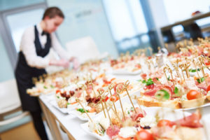 Female caterer preparing food for a large event.